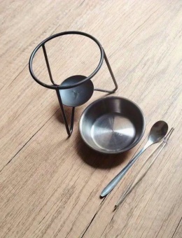 Czarna metalowa podstawka do palenia żywicy w rytualnej przestrzeni